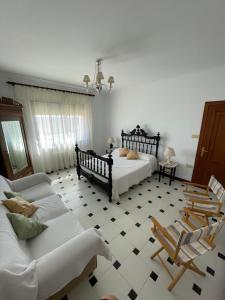 a bedroom with a bed and a couch and chairs at LAS LANZAS in Sabiote