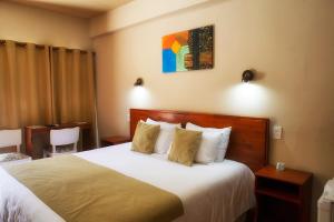 una camera d'albergo con letto con lenzuola e cuscini bianchi di Hotel FK Paso de los Toros - Hotel Boutique a Paso de los Toros
