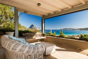 una veranda con sedia in vimini e vista sull'oceano di Molarotto a Porto Taverna