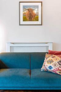 Sofá azul en una habitación con una foto en la pared en The Harrogate Townhouse en Harrogate