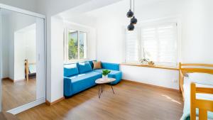 a living room with a blue couch and a window at Apartament Lux pod Karpaczem in Miłków