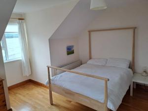 1 dormitorio con 1 cama en una habitación con ventana en Buncronan Port Self Catering en Donegal