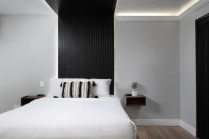 a bedroom with a white bed and a black wall at The Westerner - Extended Stay in Amarillo