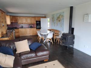 sala de estar con sofá y cocina con fogones. en Buncronan Port Self Catering, en Donegal