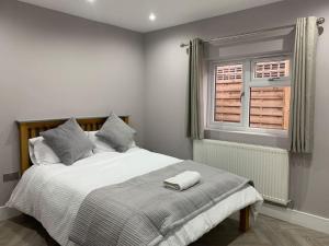 - une chambre avec un grand lit et une fenêtre dans l'établissement Stunning semi detached bungalow in West Wimbledon, à Londres