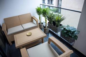 een woonkamer met een bank, stoelen en planten bij Special 1 Bed Apt W/pool View @Embassy Gard 70m2 in Cantonments