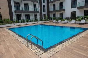 een groot blauw zwembad voor een gebouw bij Special 1 Bed Apt W/pool View @Embassy Gard 70m2 in Cantonments