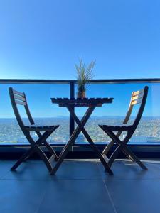 una mesa y dos sillas frente a una ventana en Cozy 2B2B Apartment with Free Parking & Penthouse Pool, en Box Hill
