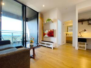 a living room with a couch and a large window at Cozy 2B2B Apartment with Free Parking & Penthouse Pool in Box Hill