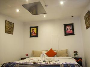 ein Schlafzimmer mit einem Bett und einige Bilder an der Wand in der Unterkunft Hotel Campanario in Cusco