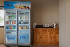 a refrigerator filled with bottles of water and drinks at Naka Residence in Phuket Town