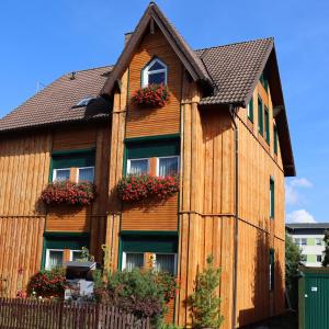 a wooden house with windows and flowers on it at Haus Sonnenruh in Oberhof