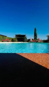 una gran piscina de agua azul con una casa en el fondo en Intero Appartamento con Private Pool e Jacuzzi Podere Settefrati, en Montaione