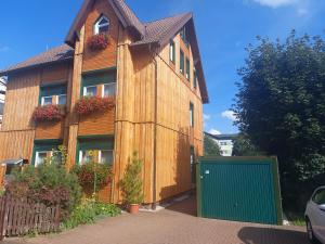 una casa in legno con un cancello verde di fronte di Haus Sonnenruh a Oberhof