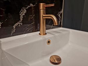 a white sink with a gold faucet in a bathroom at The Studio in Preston
