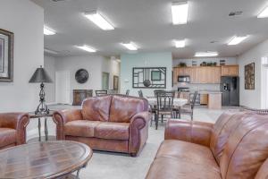 a living room with leather furniture and a kitchen at Mesquite Vacation Rental Condo with Community Pool! in Mesquite