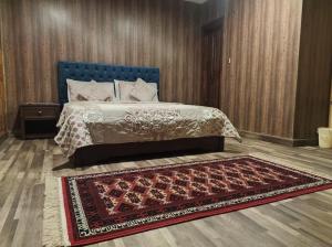 a bedroom with a bed with a blue headboard and a rug at Holiday home On The rocks in Murree