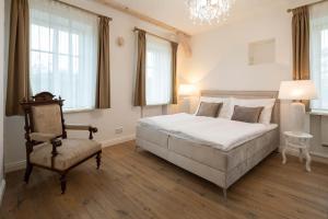 1 dormitorio con 1 cama, 1 silla y ventanas en Rezidence Palmbaum - luxury and relax, en Karlovy Vary