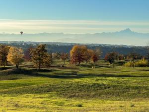 a hot air balloon flying over a field with trees at Just Langhe Casa Barolo in Novello