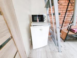 a small refrigerator with a microwave on top of it at Lampedziai Apartment in Kaunas