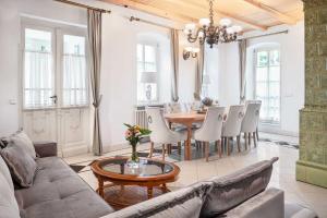 a living room with a couch and a table and chairs at Rezidence Palmbaum - luxury and relax in Karlovy Vary