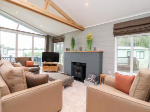 a living room with couches and a fireplace at 17 The Oaks in Skipton