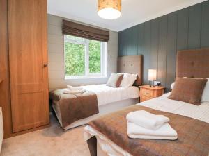 a bedroom with two beds and a window at 17 The Oaks in Skipton