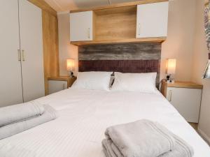 um quarto com uma cama branca com duas toalhas em 31 Willows em Skipton