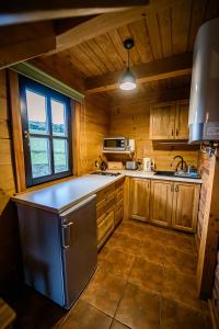 a kitchen with wooden cabinets and a large window at Sokolisko - domki całoroczne z kominkiem in Wysoczany