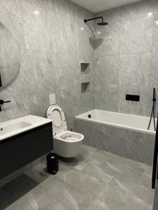 a bathroom with a toilet and a tub and a sink at Gorgeous newly refurbished 2 bedroom apartment in London in London