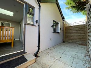 une porte ouverte d'une maison avec une terrasse dans l'établissement Stunning semi detached bungalow in West Wimbledon, à Londres