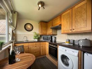 a kitchen with a table and a washing machine at Tumbleweed 2 in Dorchester