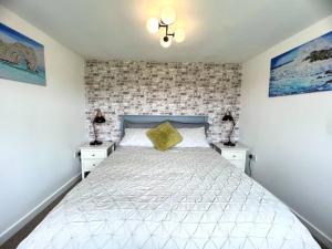1 dormitorio con 1 cama blanca y 2 mesitas de noche en Tumbleweed 2 en Dorchester