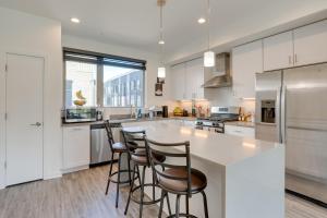 a kitchen with white cabinets and bar stools at Sleek Philadelphia Retreat with Private Rooftop in Philadelphia