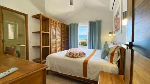 a bedroom with a bed with a view of the ocean at Albachiara Hotel - Las Terrenas in Las Terrenas