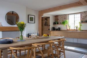 uma cozinha e sala de jantar com uma mesa de madeira e cadeiras em Relax, unwind and enjoy village life.... em Castle Acre