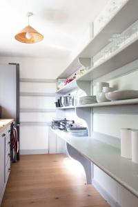 a kitchen with a white counter and shelves at Relax, unwind and enjoy village life.... in Castle Acre