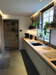 a kitchen with a counter with a sink and a door at Relax, unwind and enjoy village life.... in Castle Acre