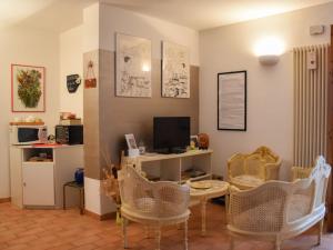 a living room with a table and chairs and a television at B&B Margherita Le Fiabe in SantʼAgata Feltria