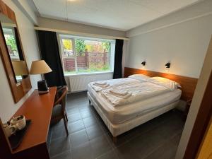 1 dormitorio con cama, escritorio y ventana en Hótel Austur, en Reyðarfjörður