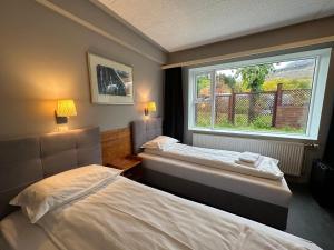 2 camas en una habitación con ventana en Hótel Austur, en Reyðarfjörður
