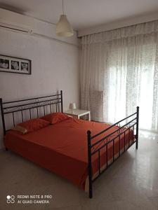una camera con un letto con copriletto rosso di Filoxenia Efi a Khortiátis