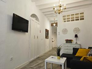 sala de estar con sofá y TV en la pared en Apartamento Casa Pura en Medina Sidonia