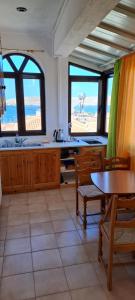 een keuken met een tafel en stoelen en uitzicht op het strand bij SIGRI'S BEAUTY in Sígrion
