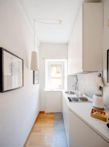 a white kitchen with white cabinets and a window at Domus Paolina in Rome