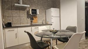 La cuisine est équipée d'une table, de chaises et d'un réfrigérateur. dans l'établissement Apartamento Casa Pura, à Medina-Sidonia