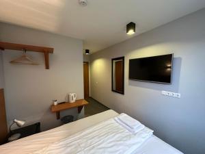 1 dormitorio con 1 cama y TV de pantalla plana en Hótel Austur en Reyðarfjörður