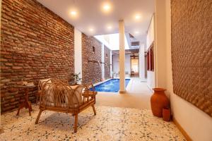 a room with a chair and a brick wall at Hotel Boutique de playa - Casa Solhu in Santa Marta