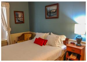 um quarto com uma cama com uma almofada vermelha em Thayers Inn em Littleton