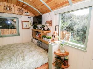 a bedroom in a tiny house with a bed and a window at Cobblers Cabin in Northampton